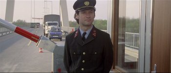 Movie still from “Bad Timing: A Sensual Obsession” (1980), directed by Nicolas Roeg – A man in a military uniform standing in front of a window; Medium shot, Low angle