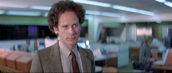 Movie still from “Bad Timing: A Sensual Obsession” (1980), directed by Nicolas Roeg – A man in a suit and tie standing in a room; Close Up shot, Over the shoulder angle