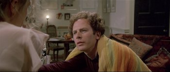 Movie still from “Bad Timing: A Sensual Obsession” (1980), directed by Nicolas Roeg – A man sitting in a living room with a blanket around his neck; Close Up shot, Low angle