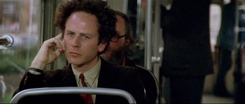 Movie still from “Bad Timing: A Sensual Obsession” (1980), directed by Nicolas Roeg – A man in a suit and red tie sitting on a bus; Close Up shot, Low angle
