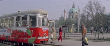 Movie still from “Bad Timing: A Sensual Obsession” (1980), directed by Nicolas Roeg – Two women are walking past a red and white bus; Extreme Wide shot, High angle