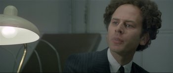 Movie still from “Bad Timing: A Sensual Obsession” (1980), directed by Nicolas Roeg – A person wearing a suit and tie; Close Up shot, Over the shoulder angle