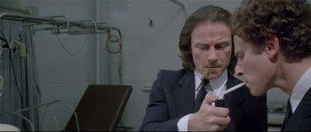 Movie still from “Bad Timing: A Sensual Obsession” (1980), directed by Nicolas Roeg – A man in a suit looking at his cell phone; Close Up shot, Low angle