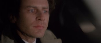 Movie still from “Bad Timing: A Sensual Obsession” (1980), directed by Nicolas Roeg – A man's face in the dark; Close Up shot, Over the shoulder angle