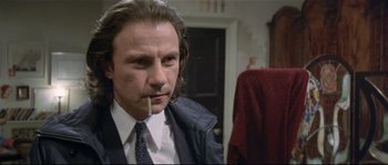 Movie still from “Bad Timing: A Sensual Obsession” (1980), directed by Nicolas Roeg – A person wearing a suit smoking a cigarette; Close Up shot, Low angle