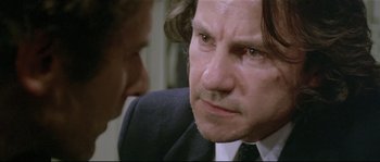 Movie still from “Bad Timing: A Sensual Obsession” (1980), directed by Nicolas Roeg – A man in a suit and tie talking to another man in a suit and tie; Close Up shot, Over the shoulder angle