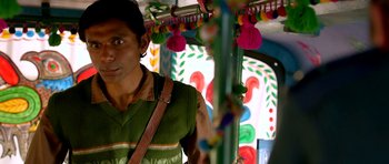 A man standing next to a pole in a bus