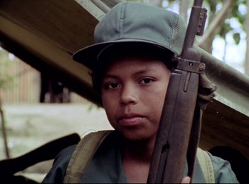 A young man holding a rifle in his hands
