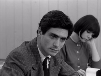 Movie still from “Band of Outsiders” (1964), directed by Jean-Luc Godard – A man and a woman sitting at a table; Close Up shot, Over the shoulder angle