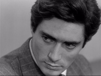 Movie still from “Band of Outsiders” (1964), directed by Jean-Luc Godard – Black and white photograph of a man in a suit; Close Up shot, Low angle