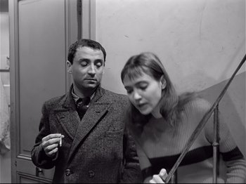Movie still from “Band of Outsiders” (1964), directed by Jean-Luc Godard – A man and a woman standing next to each other; Medium shot, Over the shoulder angle