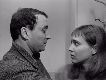 Movie still from “Band of Outsiders” (1964), directed by Jean-Luc Godard – A black and white photo of a man and a woman looking at each other; Close Up shot, High angle