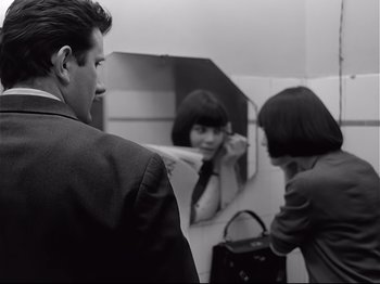 Movie still from “Band of Outsiders” (1964), directed by Jean-Luc Godard – A man and a woman looking in a mirror; Medium shot, Over the shoulder angle