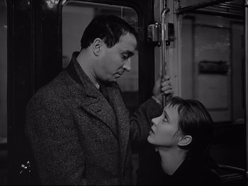 Movie still from “Band of Outsiders” (1964), directed by Jean-Luc Godard – A man and a woman on a train looking at each other; Close Up shot, Low angle