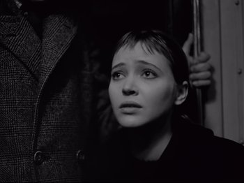 Movie still from “Band of Outsiders” (1964), directed by Jean-Luc Godard – A young woman looking up at the sky; Close Up shot, Over the shoulder angle