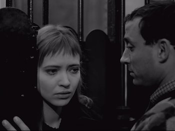 Movie still from “Band of Outsiders” (1964), directed by Jean-Luc Godard – A man and a woman standing next to each other; Close Up shot, High angle