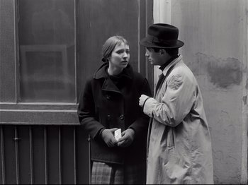 Movie still from “Band of Outsiders” (1964), directed by Jean-Luc Godard – A man and a woman standing next to each other; Medium shot, Over the shoulder angle