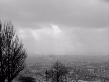 Movie still from “Band of Outsiders” (1964), directed by Jean-Luc Godard – A black and white photo of a city in the rain; Extreme Wide shot, High angle