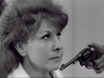 Movie still from “Band of Outsiders” (1964), directed by Jean-Luc Godard – A black and white photo of a woman smoking a pipe; Close Up shot, High angle
