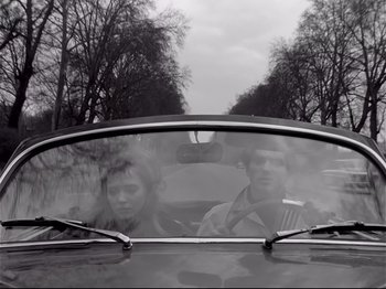 Movie still from “Band of Outsiders” (1964), directed by Jean-Luc Godard – A man and a woman in the back seat of a car; Medium shot, Low angle