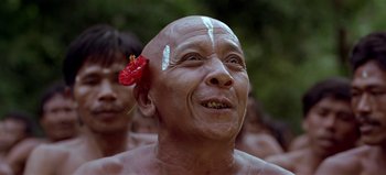 Movie still from “Baraka” (1992), directed by Ron Fricke – A man with a flower in his hair; Close Up shot, Low angle