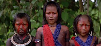 Movie still from “Baraka” (1992), directed by Ron Fricke – A young girl with tattoos on her body and two other young girls; Close Up shot, Low angle