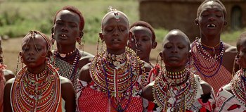 Movie still from “Baraka” (1992), directed by Ron Fricke – A group of women in traditional clothing standing together; Medium shot, Low angle