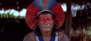 Movie still from “Baraka” (1992), directed by Ron Fricke – A man with a red , blue , and white headdress on; Close Up shot, Low angle