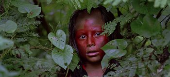 Movie still from “Baraka” (1992), directed by Ron Fricke – A young girl with red paint on her face; Close Up shot, Low angle