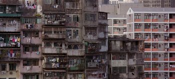Movie still from “Baraka” (1992), directed by Ron Fricke – A group of old buildings that have been boarded up; Extreme Wide shot, High angle