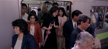 Movie still from “Baraka” (1992), directed by Ron Fricke – A group of people riding on a subway train; Medium shot, High angle