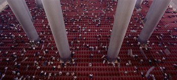 Movie still from “Baraka” (1992), directed by Ron Fricke – A group of people laying down in a theater; Extreme Wide shot, Overhead angle