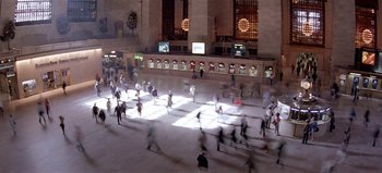 Movie still from “Baraka” (1992), directed by Ron Fricke – A crowd of people walking around a building at night; Extreme Wide shot, High angle
