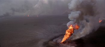 Movie still from “Baraka” (1992), directed by Ron Fricke – An image of an oil well fire in the middle of the night; Extreme Wide shot, High angle