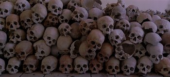 Movie still from “Baraka” (1992), directed by Ron Fricke – A pile of skulls sitting on top of each other; Wide shot, Overhead angle