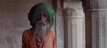 Movie still from “Baraka” (1992), directed by Ron Fricke – An old man with long hair and a beard wearing a green turban; Close Up shot, Low angle