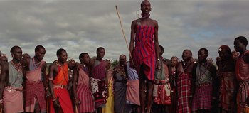 Movie still from “Baraka” (1992), directed by Ron Fricke – A group of people standing in a field; Wide shot, Low angle