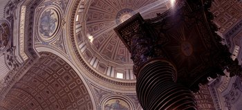 Movie still from “Baraka” (1992), directed by Ron Fricke – The dome of a church with a pillar in the center of it; Extreme Wide shot, Low angle