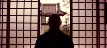 Movie still from “Baraka” (1992), directed by Ron Fricke – A man standing in front of an open window; Medium shot, Low angle