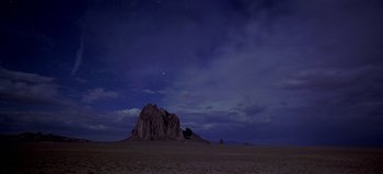 Movie still from “Baraka” (1992), directed by Ron Fricke – A rock formation in the middle of a desert at night; Extreme Wide shot, Low angle