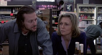 Movie still from “Barfly” (1987), directed by Barbet Schroeder – A man and a woman sitting at a table in a store; Close Up shot, Over the shoulder angle