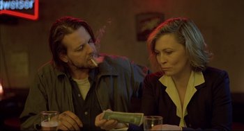 Movie still from “Barfly” (1987), directed by Barbet Schroeder – A man and a woman sitting next to each other at a table; Medium shot, Over the shoulder angle