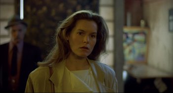 Movie still from “Barfly” (1987), directed by Barbet Schroeder – A woman with long brown hair wearing a white shirt; Close Up shot, Over the shoulder angle