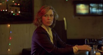 Movie still from “Barfly” (1987), directed by Barbet Schroeder – A woman sitting in front of a tv in a dark room; Close Up shot, Low angle