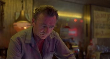 Movie still from “Barfly” (1987), directed by Barbet Schroeder – A person sitting at a table; Close Up shot, Low angle