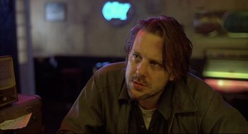 Movie still from “Barfly” (1987), directed by Barbet Schroeder – A person sitting at a table; Close Up shot, Low angle