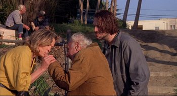 Movie still from “Barfly” (1987), directed by Barbet Schroeder – Two men and an older woman looking through a pair of binoculars; Medium shot, Over the shoulder angle