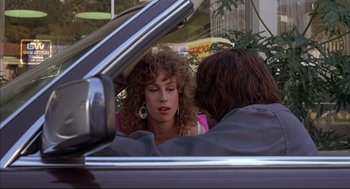 Movie still from “Barfly” (1987), directed by Barbet Schroeder – A woman sitting next to a man in the back of a car; Close Up shot, Over the shoulder angle