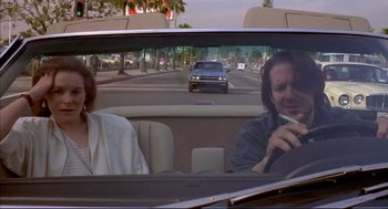 Movie still from “Barfly” (1987), directed by Barbet Schroeder – A man and a woman in the back seat of a car; Medium shot, Over the shoulder angle