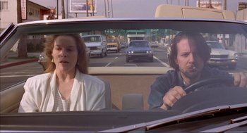 Movie still from “Barfly” (1987), directed by Barbet Schroeder – A man and a woman in the back seat of a car; Medium shot, Low angle